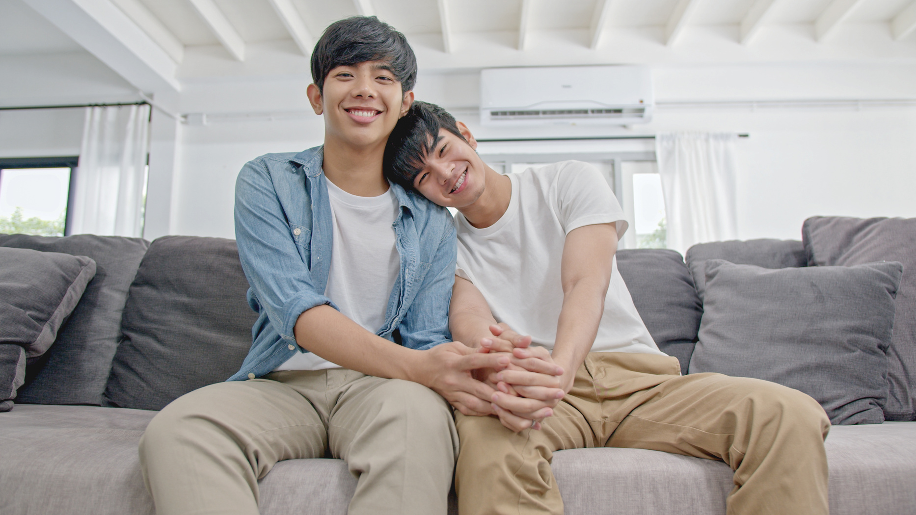 Young cuYoung cute asian gay loving couple holding on Sofa.teens homosexual couple.LGBTG Concept.Love and Relationshipste asian gay couple looking to laptop.teens homosexual couple.LGBTQ Concept.Love and Relationships